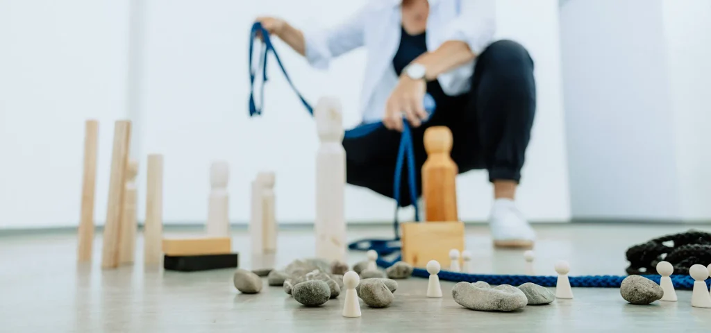 Coaching mit Holzfiguren, Steinen und einem Seil